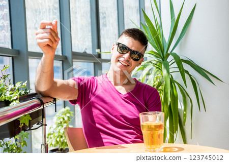Young man in the pub. Drinking beer, eating pizza. 123745012
