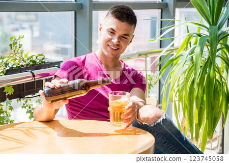 Young man in the pub. Drinking beer, eating pizza. 123745058