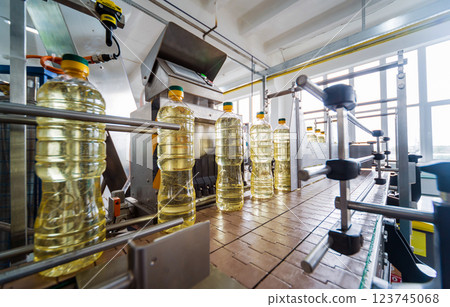 Bottling line of sunflower oil in bottles. Vegetable oil production plant.  123745068