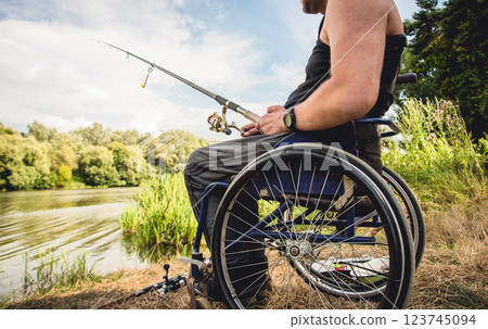 Handicapped man fishing at a lake. Wheelchair camping. Handicapped man fishing at a lake. Wheelchair camping. 123745094
