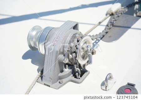 Anchor winch with sturdy chain on a voyage boat, ensuring stability and security Anchor winch with sturdy chain on a voyage boat, ensuring stability and security 123745104