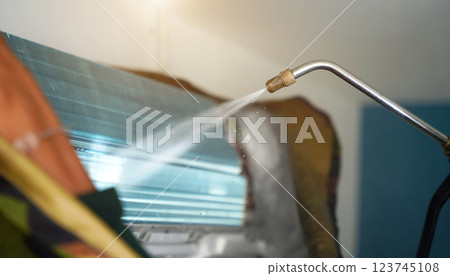 The worker cleans and repairs the air conditioner to ensure it operates properly 123745108