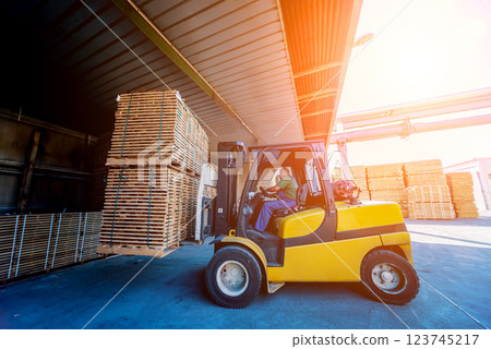 Forklift loader load lumber into a dry kiln. Wood drying in containers. Forklift loader load lumber into a dry kiln. Wood drying in containers. 123745217