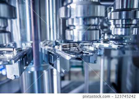 Automatic filling machine pours water into plastic PET bottles. Automatic filling machine pours water into plastic PET bottles. 123745242