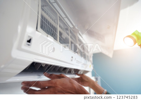 The worker cleans and repairs the air conditioner to ensure it operates properly The worker cleans and repairs the air conditioner to ensure it operates properly 123745283