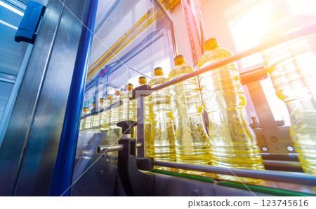Bottling line of sunflower oil in bottles. Vegetable oil production plant Bottling line of sunflower oil in bottles. Vegetable oil production plant 123745616