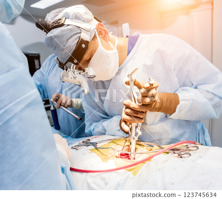 Spinal surgery. Group of surgeons in operating room with surgery equipment.  123745634