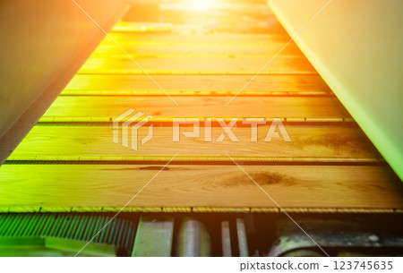 Production line of the wooden floor factory. CNC automatic woodworking machine. Production line of the wooden floor factory. CNC automatic woodworking machine. 123745635