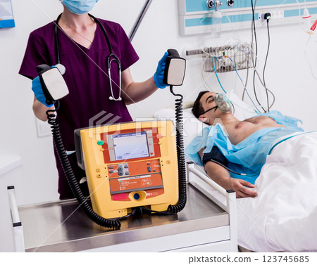 Doctors give resuscitation to a male patient in the emergency room. 123745685