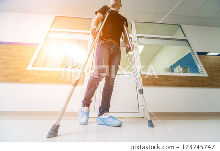 Injured man trying to walk on crutches in the hospital. 123745747