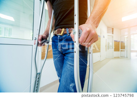 Injured man trying to walk on crutches in the hospital. Injured man trying to walk on crutches in the hospital. 123745798