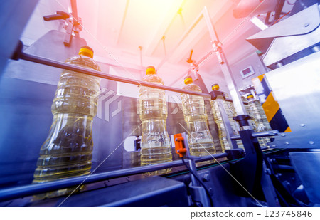 Bottling line of sunflower oil in bottles. Vegetable oil production plant Bottling line of sunflower oil in bottles. Vegetable oil production plant 123745846