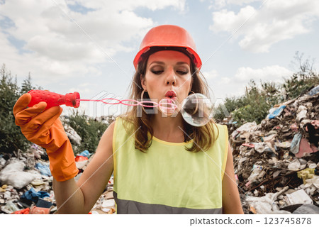 Woman volunteer with bubbles helps clean the field of plastic garbage. Woman volunteer with bubbles helps clean the field of plastic garbage. 123745878