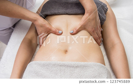 Beautiful young woman enjoying massage in spa salon. Cosmetology 123745889