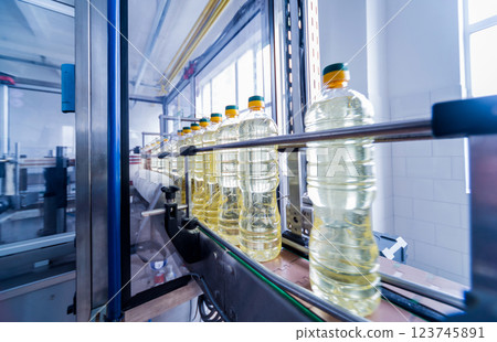Bottling line of sunflower oil in bottles. Vegetable oil production plant 123745891