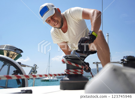 A man in a white hat is working on a voyage boat A man in a white hat is working on a voyage boat 123745946