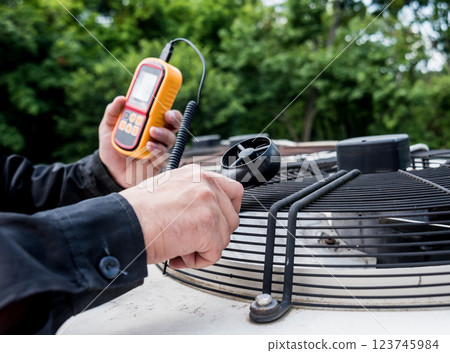 Technician use hand-held anemometer measuring air flowing measurement 123745984