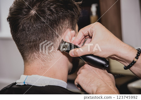 Young man with trendy haircut at barber shop. Young man with trendy haircut at barber shop. 123745992