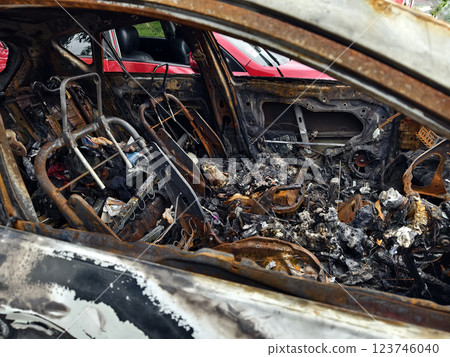 Charred remnants of a vehicle interior left behind after a devastating fire incident 123746040