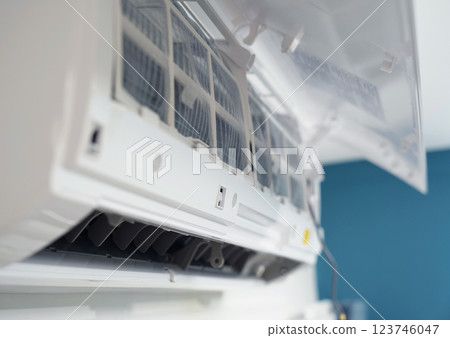 The worker cleans and repairs the air conditioner to ensure it operates properly 123746047