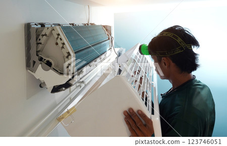 The worker cleans and repairs the air conditioner to ensure it operates properly The worker cleans and repairs the air conditioner to ensure it operates properly 123746051