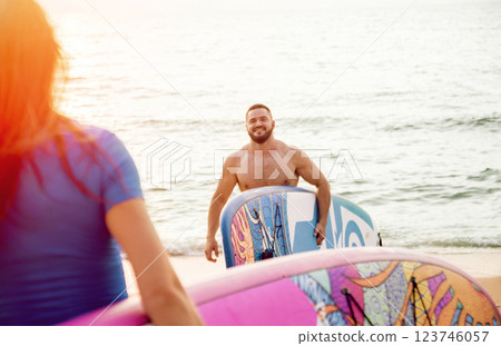 Two young surfers going into the sea with surf boards 123746057