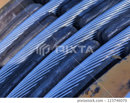 A large wooden spool of high-voltage electric wires is located on the road 123746070