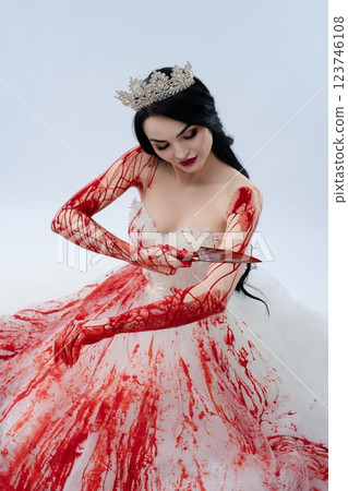 Gory bridal beauty poses with bloodied knife in a hauntingly elegant manner Gory bridal beauty poses with bloodied knife in a hauntingly elegant manner 123746108