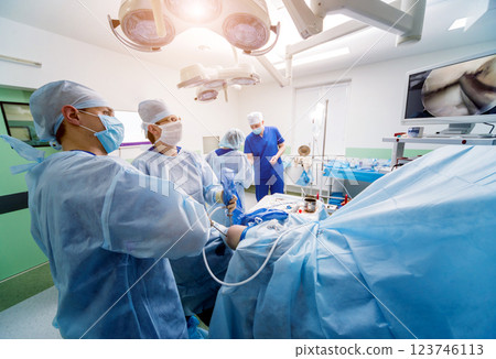 Arthroscope surgery. Orthopedic surgeons in teamwork in the operating room  123746113