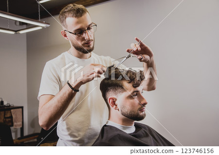 Young man with trendy haircut at barber shop.  123746156