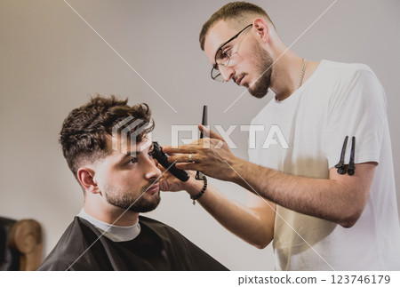Young man with trendy haircut at barber shop.  123746179
