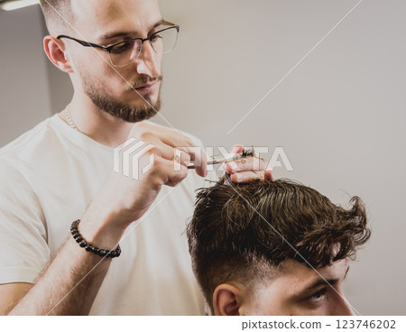Young man with trendy haircut at barber shop.  123746202