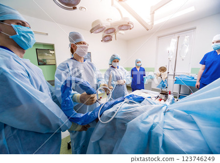 Arthroscope surgery. Orthopedic surgeons in teamwork in the operating room  123746249