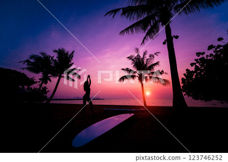 Silhouette of surfer girl with long surf board at sunset on tropical beach Silhouette of surfer girl with long surf board at sunset on tropical beach 123746252