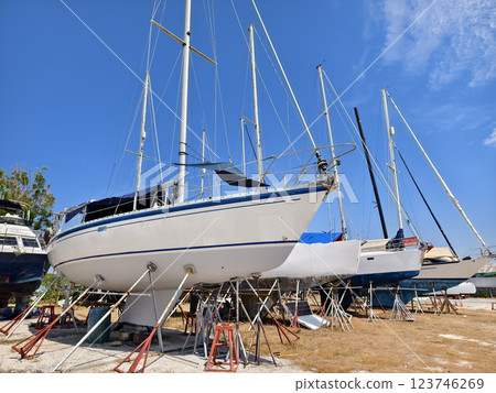 A white voyage boat featuring a steering wheel floating in the dock A white voyage boat featuring a steering wheel floating in the dock 123746269