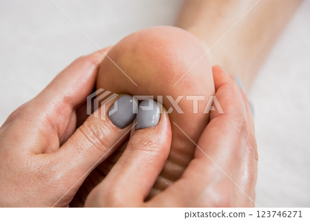 Beautiful young woman enjoying foot massage in spa salon. Cosmetology 123746271