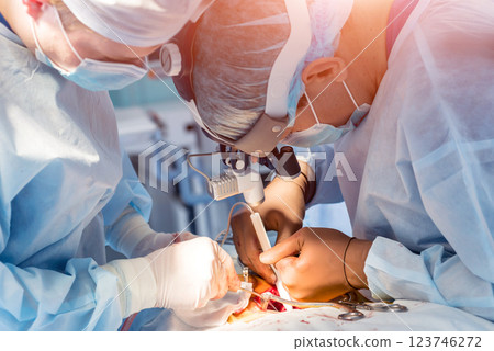 Spinal surgery. Group of surgeons in operating room with surgery equipment.  123746272