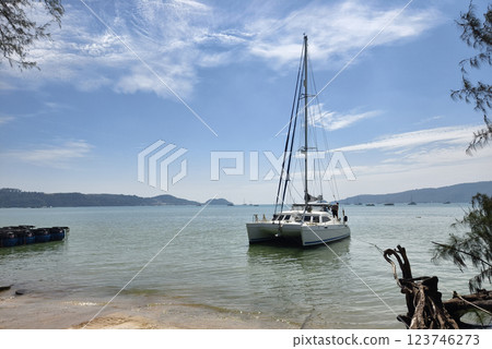 A white voyage boat featuring a steering wheel floating in the water A white voyage boat featuring a steering wheel floating in the water 123746273