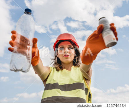 Woman volunteer helps clean the field of plastic garbage.  123746284