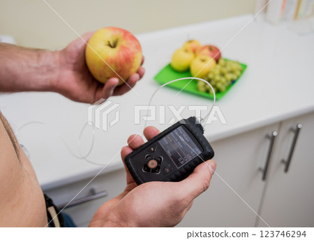 Diabetic man with an insulin pump connected in his abdomen. insulin pump calculates the dose of insulin. Diabetes concept. Diabetic man with an insulin pump connected in his abdomen. insulin pump calculates the dose of insulin. Diabetes concept. 123746294