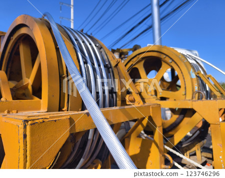 A large wooden spool of high-voltage electric wires is located on the road A large wooden spool of high-voltage electric wires is located on the road 123746296