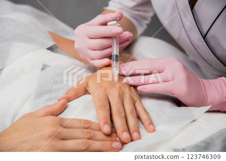 The doctor cosmetologist makes the arms injections procedure. The doctor cosmetologist makes the arms injections procedure. 123746309