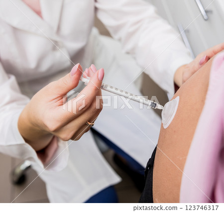 Doctor makes an injection of insulin with a catheter. Doctor injects insulin to a patient with diabetes through a catheter. Diabetes concept. 123746317