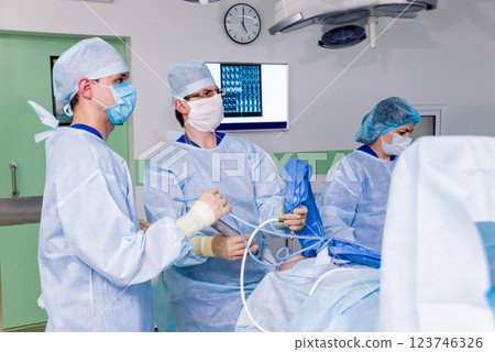 Arthroscope surgery. Orthopedic surgeons in teamwork in the operating room  123746326