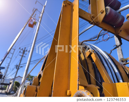 Installation of high-voltage electric wires on new poles along the road Installation of high-voltage electric wires on new poles along the road 123746353