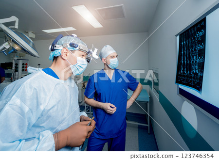 Spinal surgery. Group of surgeons in operating room with surgery equipment. Spinal surgery. Group of surgeons in operating room with surgery equipment. 123746354