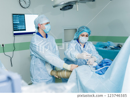 Arthroscope surgery. Orthopedic surgeons in teamwork in the operating room  123746385