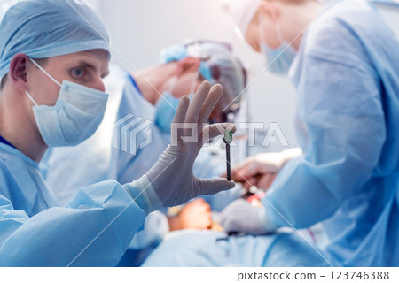 Spinal surgery. Group of surgeons in operating room with surgery equipment. 123746388