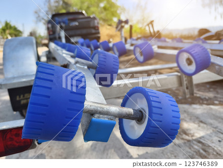 Detailed closeup of a boat trailer that features striking blue wheels 123746389