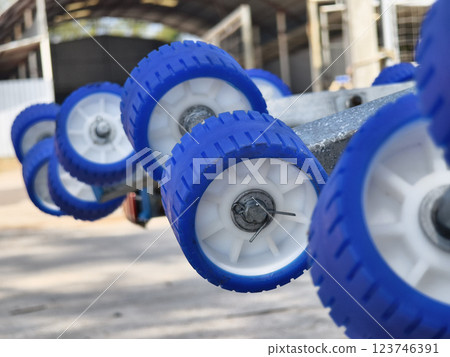 Detailed closeup of a boat trailer that features striking blue wheels Detailed closeup of a boat trailer that features striking blue wheels 123746391